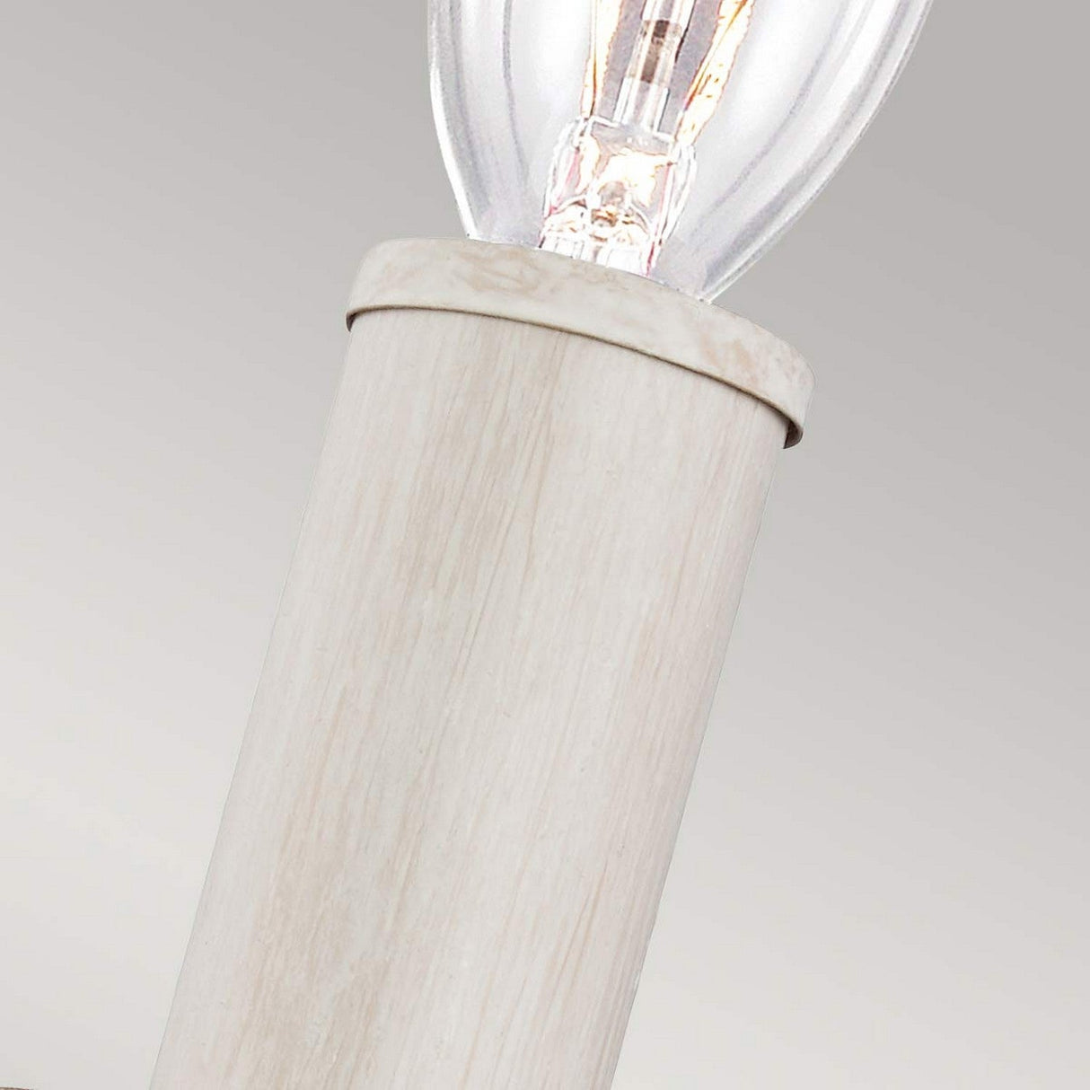 Close-up of the Hartsville 1 Light Wall Light in a wooden beachwood socket, radiating rustic charm with its glowing filament against a neutral background. This design seamlessly integrates farmhouse style into any chalk-washed finish décor.