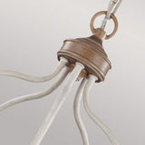 Close-up of the Hartsville 5 Light Chandelier, featuring a beachwood top and curved metal arms in a chalk-washed finish, showcasing farmhouse-inspired design. This chandelier, ideal for versatile placement options, hangs from a metal chain against a neutral background.