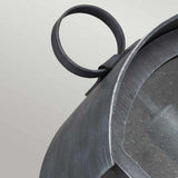 A close-up view of the Hodges Outdoor Large Wall Lantern in Ash Black showcases its metallic, industrial-style design featuring a curved handle and a glass panel. Its weathered ash black finish enhances its rustic charm, making it an ideal complement to farmhouse aesthetics against a neutral background.