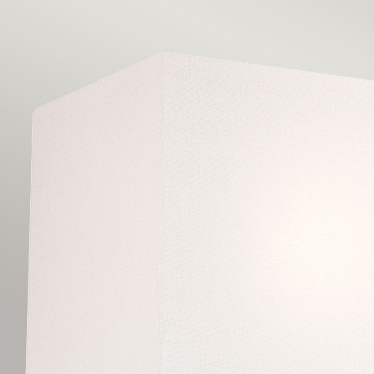 In the upper corner, a close-up of the Indo 1 Light Wall Light's off white cotton shade is set against a light gray background, showcasing its contemporary aesthetic. The shade has a smooth texture and clean lines that highlight its minimalist design, while the aged iron finish introduces a subtle rustic charm through gentle contrast.