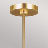 A gold ceiling light fixture with a cylindrical base and a round, flat canopy against a light gray background showcases an Art Deco design. Made from burnished brass, this piece reflects the sophistication of the Jax 10 Light Chandelier - Burnished Brass.