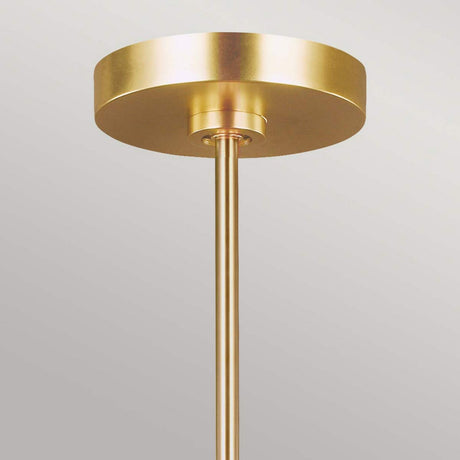 A gold ceiling light fixture with a cylindrical base and a round, flat canopy against a light gray background showcases an Art Deco design. Made from burnished brass, this piece reflects the sophistication of the Jax 10 Light Chandelier - Burnished Brass.