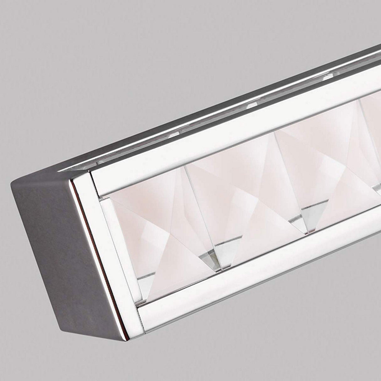 Close-up of the Jessie 1 Light LED Wall Light in polished chrome, showcasing its modern rectangular design with a metallic frame and an intricate pattern of faceted crystals inside, set against a plain gray background.