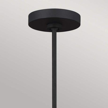 A minimalist Joan 5 Light Chandelier in midnight black and burnished brass showcases a cylindrical base and a long vertical rod, set elegantly against a light gray background.