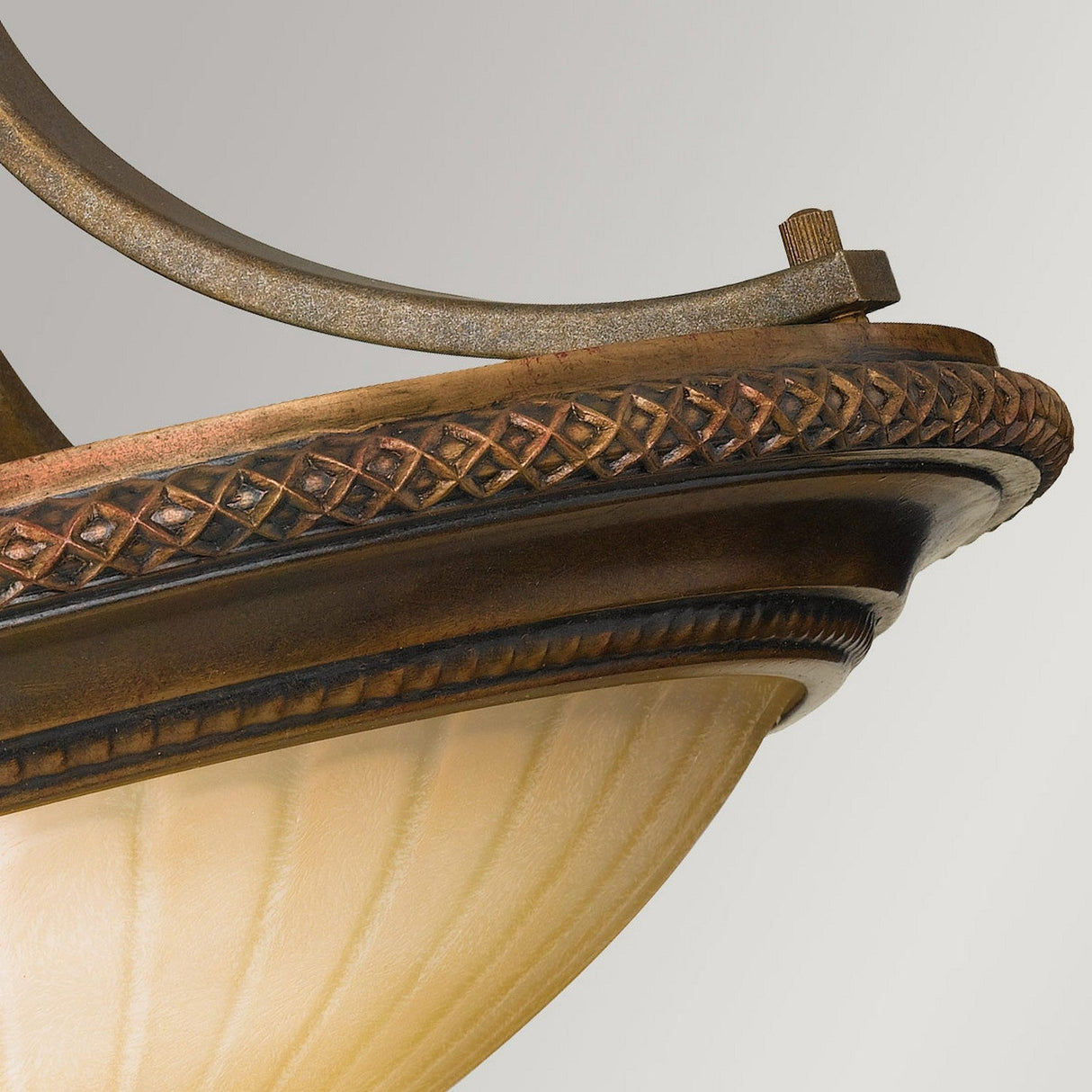 Close-up of an ornate Kelham Hall 2 Light Semi Flush fixture, showcased in a British Bronze finish with intricate patterns and a frosted glass dome that accentuates the refined detailing of the metalwork.
