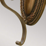 Close-up of an ornate metal hook in a British Bronze hue against a light gray background. The design showcases intricate patterns and a curved shape, with a textured oval detail at the top, similar to the craftsmanship found in Kelham Hall 1 Light Wall Light fixtures.