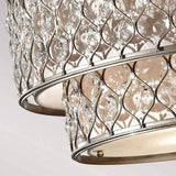 A close-up of the Lucia 6 Light Chandelier in Burnished Silver showcases its elegant and luxurious appearance with sparkling Bauhinia crystals against a neutral background.