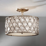 The Lucia 1 Light Semi Flush fixture, with its burnished silver metal frame and Bauhinia crystals, casts a warm and elegant glow. The design is enhanced by diamond-shaped crystal inserts, adding a touch of sophistication to any room.
