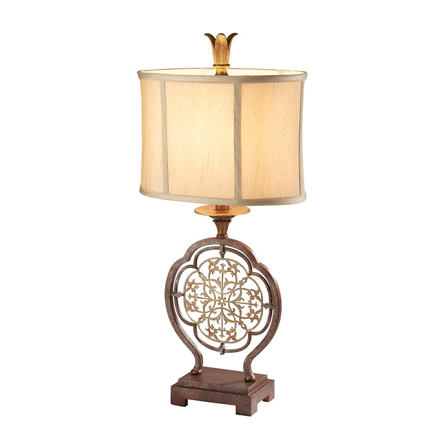 Introducing the Marcella 1 Light Table Lamp - Bronze, featuring a beige rectangular faux silk shade and an ornate metal base. The intricate filigree details form a circular pattern on the base, complemented by a delicate leaf-shaped finial.