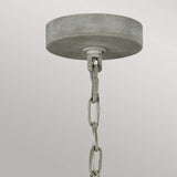 A close-up of a ceiling light fixture with a metallic, circular canopy and a chain hanging from it exudes rustic charm. This Maryville 9 Light Chandelier - Washed Grey stands out against a plain, light gray background, effortlessly blending elegance with French Country sophistication.