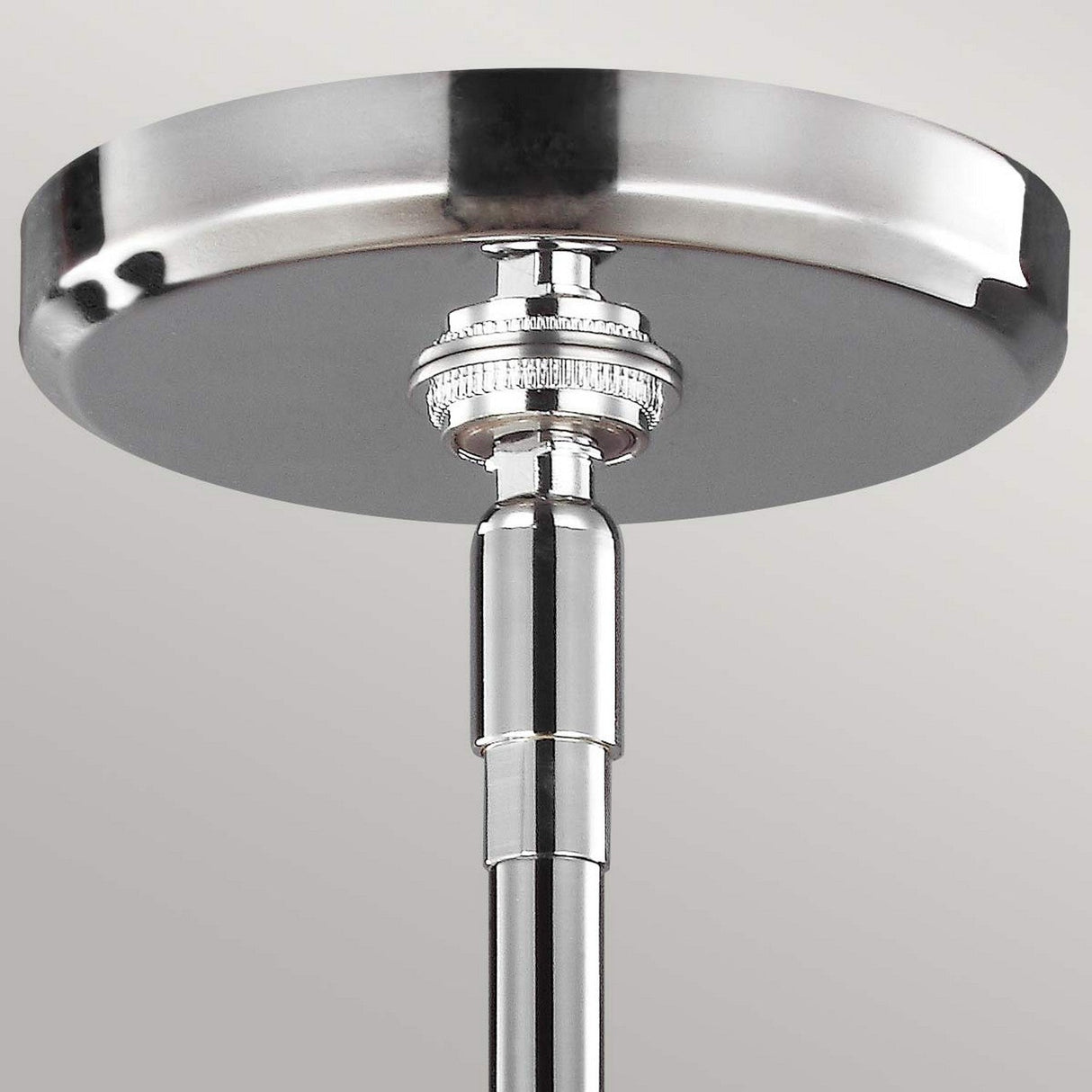 Close-up of the Paulson 3 Light Pendant in chrome showcasing its sleek design, modern finish, adjustable stem, and vintage glass detailing, set against a light gray background.
