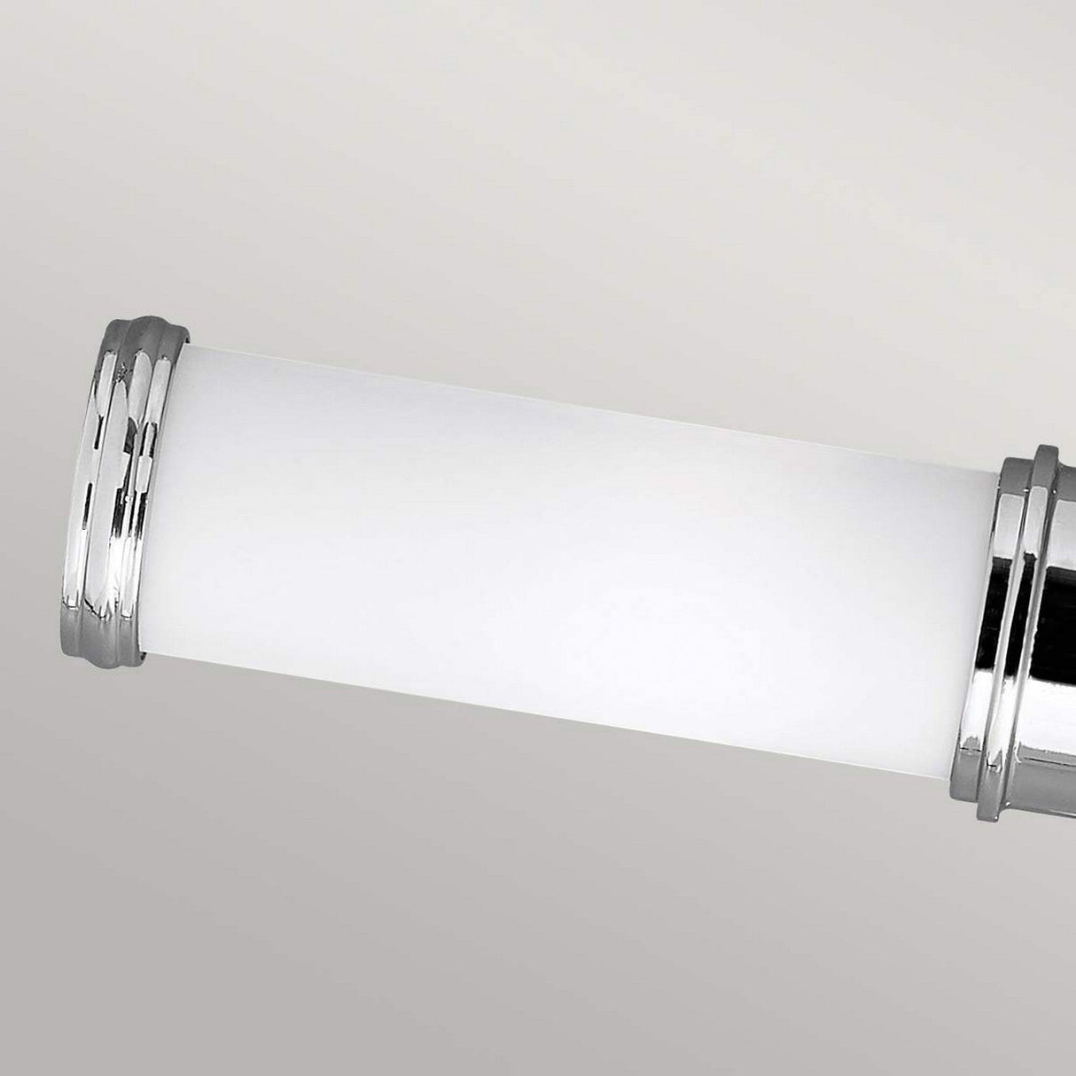 The Payne-1 2 Light Wall Light in polished chrome, designed with a horizontal cylindrical shape and frosted white glass body, is elegantly mounted on a light gray wall. It boasts an IP44 rating for added durability.