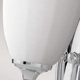 Close-up of the Perry 1 Light Wall Light in polished chrome, showcasing its opal glass shade. The sleek and minimalistic design makes it an ideal bathroom light for reflecting a contemporary style.
