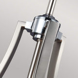 Close-up of the Prospect Park 4 Light Chandelier, showcasing its sleek, geometric lines with a central cylindrical fixture adorned with opal etched glass shades. The neutral background amplifies the Satin Nickel and Chrome finish, elegantly highlighting its modern design.