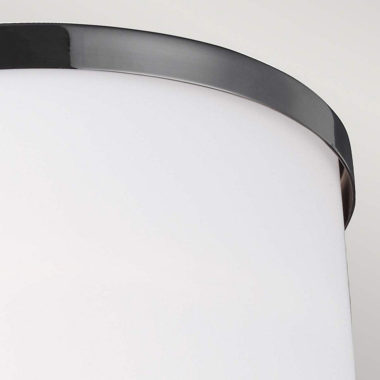 Close-up of the Prospect Park 1 Light Wall Light showcasing a sleek cylindrical white shade with satin nickel and chrome accents. The metallic rim adds elegance, while the top portion gleams against a light gray background.