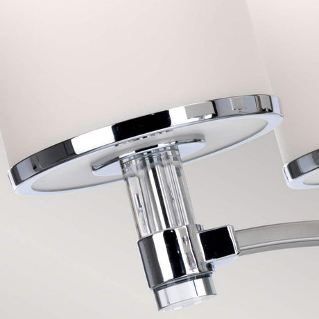 A detailed perspective of the Prospect Park 5 Light Chandelier in Satin Nickel with Chrome showcases its modern elegance. It features a cylindrical frosted glass shade, chrome accents, and a clear glass cylindrical connector that seamlessly integrates into transitional spaces with its sleek, contemporary design.