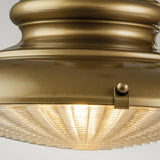 Close-up of a vintage Redding Station 1 Light Outdoor Medium Wall Lantern in bronze, featuring a ribbed glass cover that is softly illuminated. The design exudes timeless elegance with its classic and sophisticated appearance.