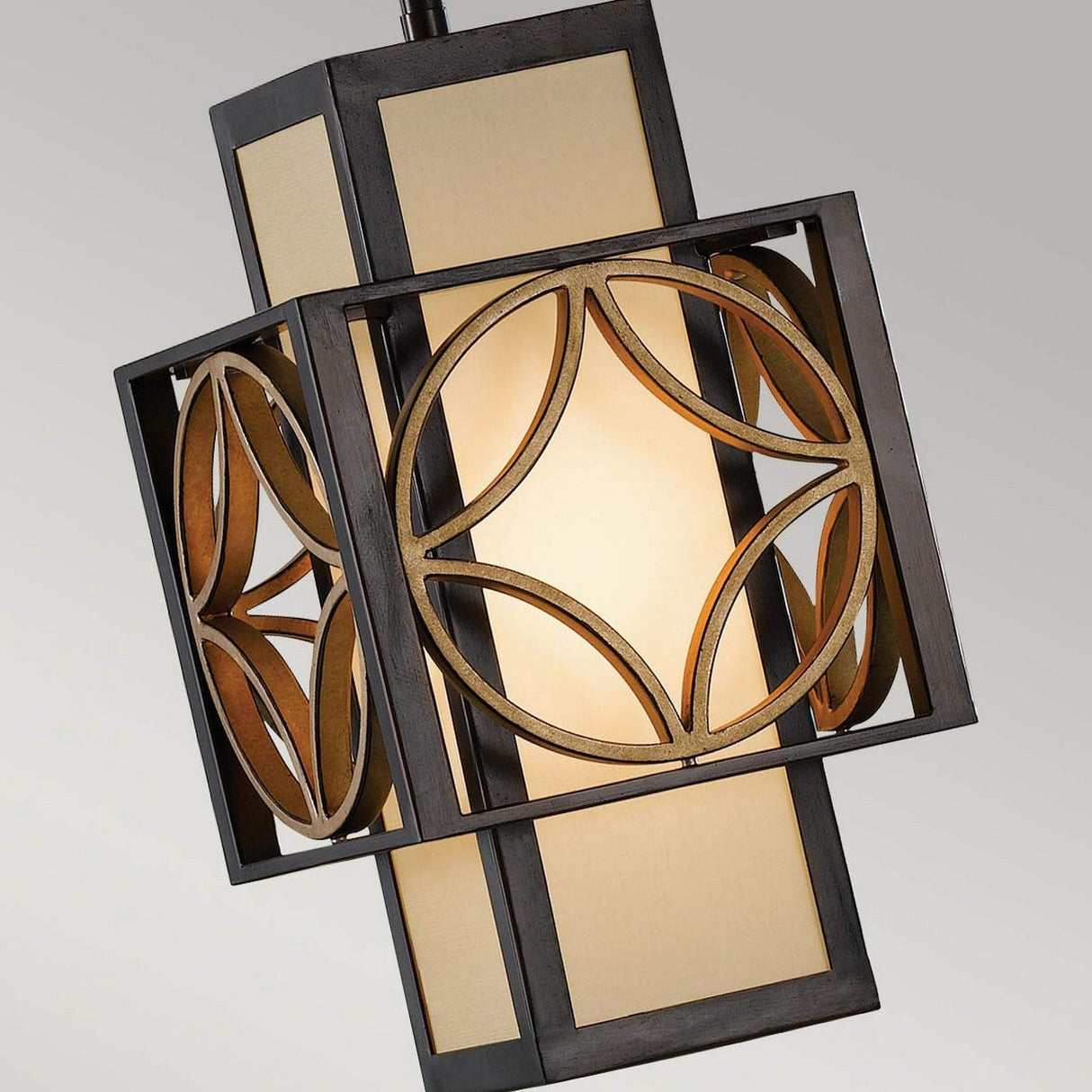 Introducing the Remy 1 Light Pendant Light in Heritage Bronze/Parissiene Gold, showcasing a decorative geometric design. This fixture features a square frame adorned with circular patterns that encase a warm, glowing light within pale, translucent panels. The heritage bronze metal frame enhances its contemporary elegance.