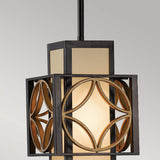 The Remy 1 Light Pendant Light in Heritage Bronze/Parissiene Gold features a contemporary design with a geometric metal frame that encases a frosted glass shade. It boasts circular patterns, a dark finish, and is suspended by a black rod, casting a warm glow when illuminated.