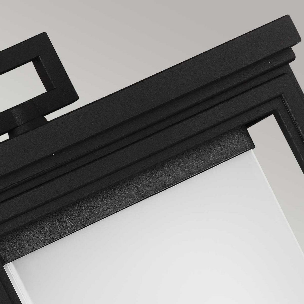 Here's a revised sentence using the product data:

"Close-up of the Roscoe 1 Light Outdoor Large Wall Lantern in black, showcasing its frosted glass panel. The frame embodies a minimalistic design with right angles and a smooth surface, offering a contemporary and sleek aesthetic ideal for outdoor use.