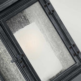 Close-up of the Shepherd 1 Light Outdoor Extra Large Wall Lantern in Dark Weathered Zinc, featuring a frosted glass design with a black metal frame, adorned with water droplets. A soft light glows through the glass, reminiscent of vintage street lighting, creating a warm and diffused illumination.