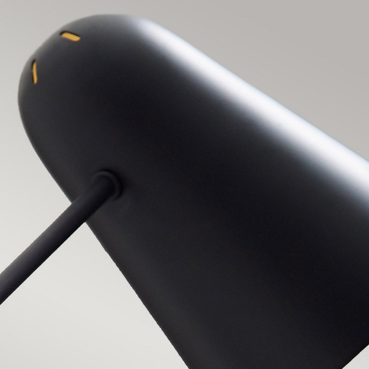 Close-up of the Simon 1 Light Wall Light - Black, showcasing its adjustable arm and sleek, modern cylindrical head set against a gray background.