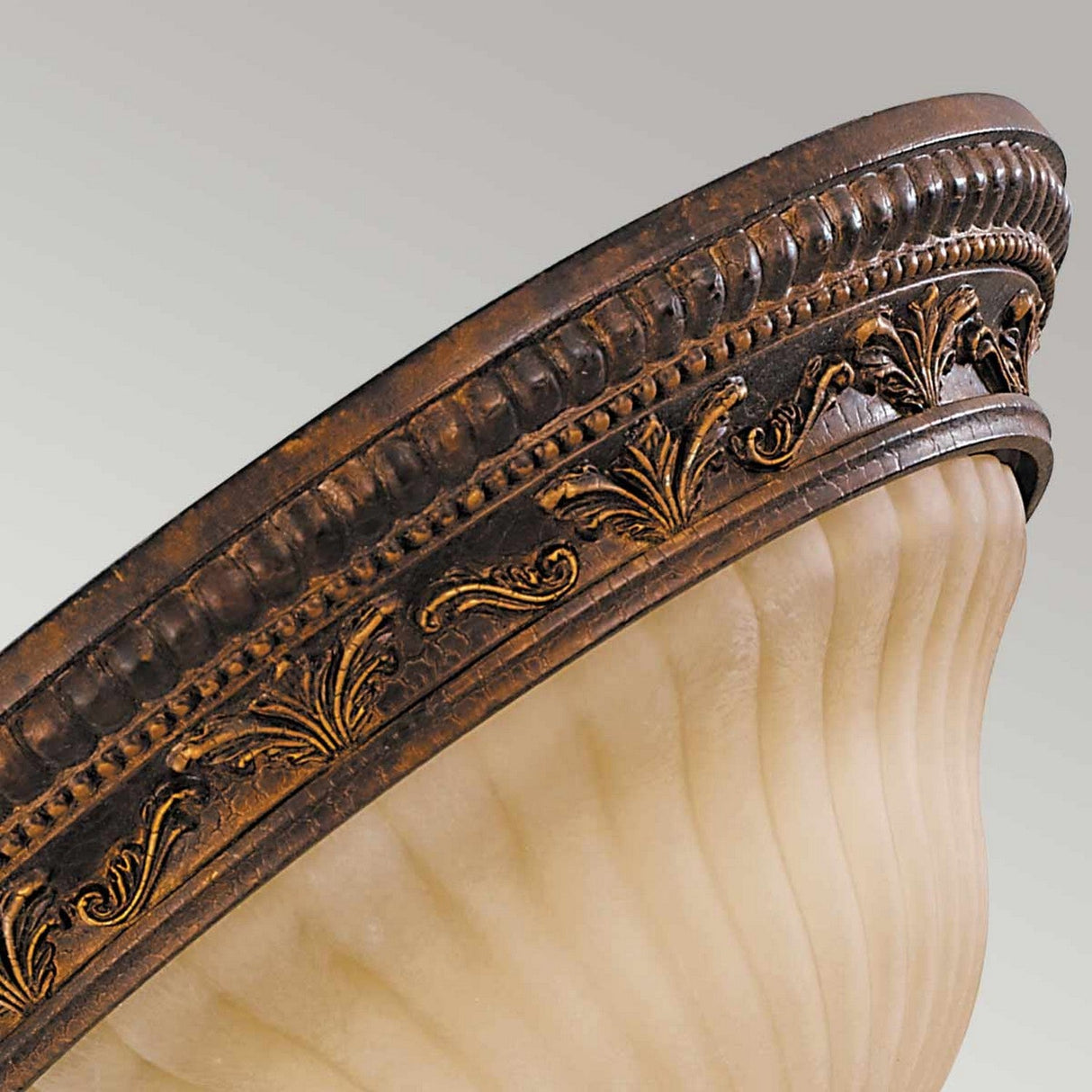 Close-up of the Sonoma Valley 2 Light Flush, showcasing its ornate embossed patterns. The design features raised floral motifs and intricate detailing along the rim, exuding a French Country style with its cream and weathered bronze finish complemented by a frosted glass appearance.