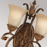 The Sonoma-1 Valley 2 Light Wall Light in cream and bronze offers a vintage aesthetic with its ornate design, featuring two fluted, frosted glass shades. Its intricate leaf and scroll patterns add an elegant charm that evokes the essence of Sonoma Valley against a neutral backdrop.