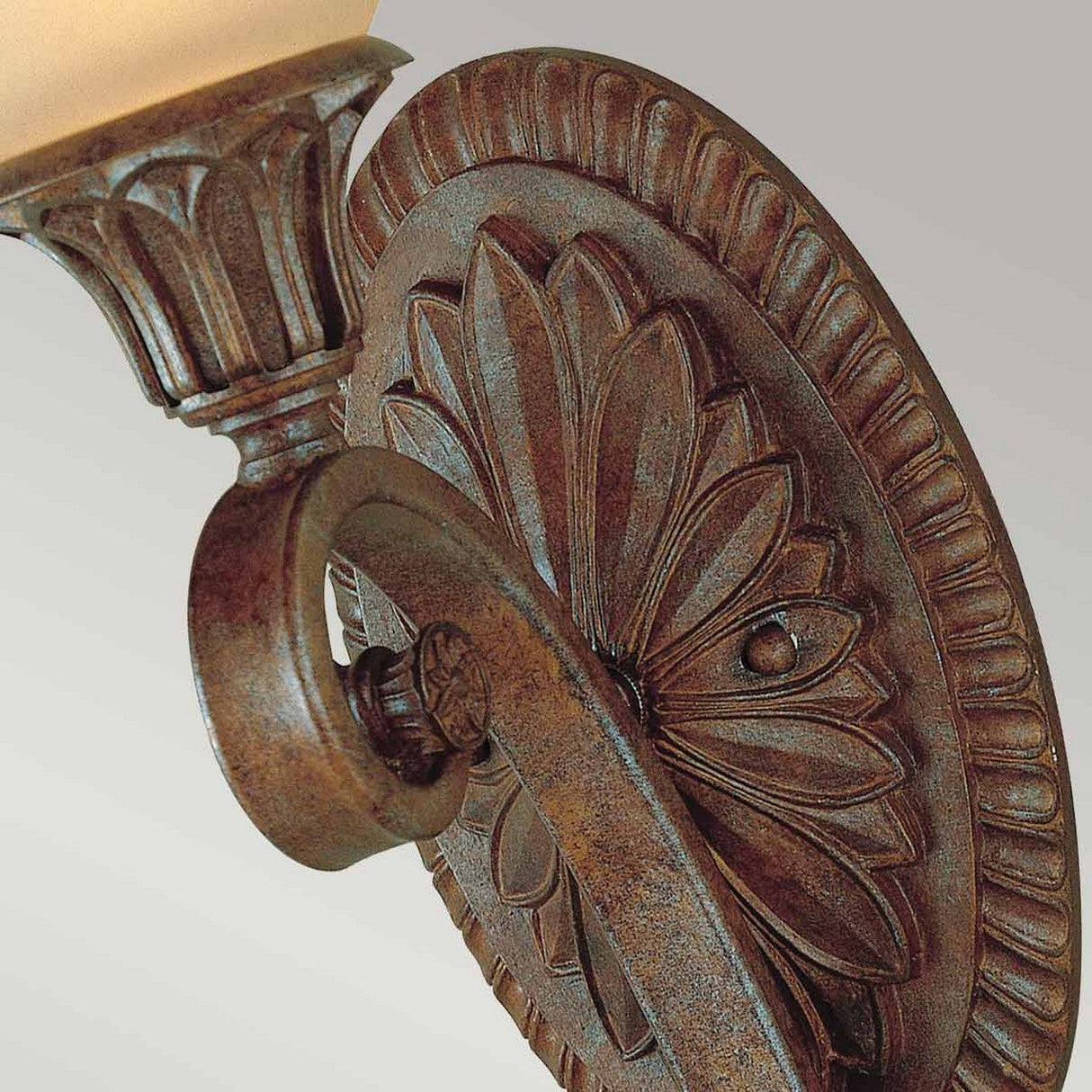 Here's a rewritten version of the sentence using the given product data:

A close-up of the Stirling-1 Castle 1 Light Wall Light in Bronze showcases this decorative wall sconce's vintage allure with its floral design and elegant rust-colored finish. The sconce features a light fixture with a cream-colored glass shade set against a simple gray background.