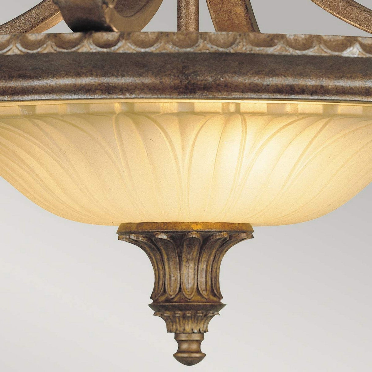 A close-up of the Stirling Castle 2 Light Semi Flush in a bronze finish showcases its frosted glass bowl. This fixture features a detailed metal design with classical decorative elements on the base and rim.
