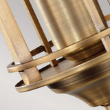 Close-up of the Urban Renewal 1 Light Wall Light in dark antique brass, showcasing industrial elegance. Its cylindrical shape is encircled by intersecting rings resembling a protective cage. The metal shines in an antique brass tone, reminiscent of an Edison-style bulb, against a plain background.