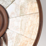 A close-up of the Urban Renewal 1 Light Wall Light - Bronze reveals its circular stained glass window with metal framing that resembles vintage lighting. The frosted colors and abstract patterns radiate outward like pie slices against a neutral background, evoking the charm of an industrial wall light.