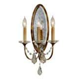 The Valentina 3 Light Wall Light - Oxidized Bronze is a timeless wall sconce featuring an oval mirrored back with three candle-style lights on decorative stems. Elegantly finished in oxidized bronze, it is adorned with polished glass crystals hanging beneath each bulb, adding a touch of vintage charm and sophistication.