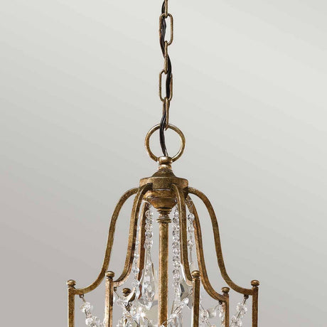 A close-up of the Valentina 6 Light Chandelier - Oxidized Bronze highlights its exquisite design with a metallic frame finished in oxidized bronze. It is adorned with polished glass crystals and suspended by a chain, adding luxury to a neutral light gray background.