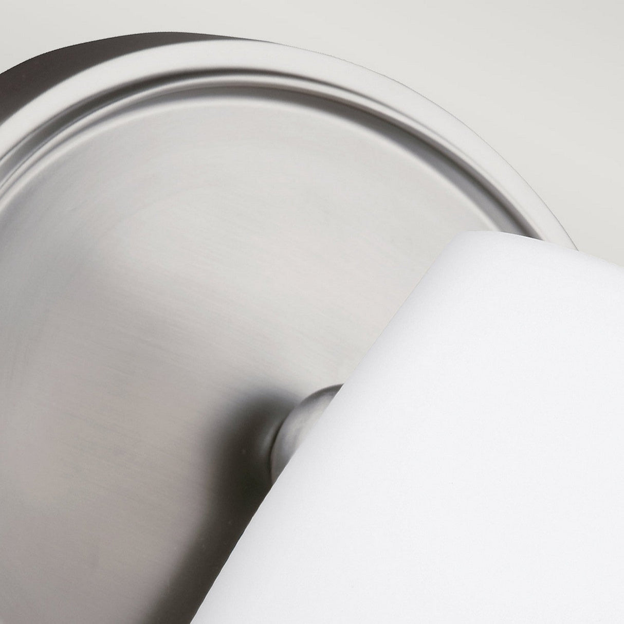 A close-up of a partially unrolled white toilet paper roll mounted on a Vintner 1 Light Wall Light with a satin nickel finish.