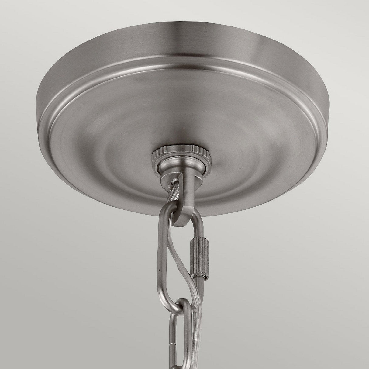 The Vintner 3 Light Chandelier in Satin Nickel is elegantly supported by a brushed metal ceiling canopy with an attached chain. It features opal etched glass shades and a satin nickel finish, ensuring a secure connection against the smooth, light gray background.
