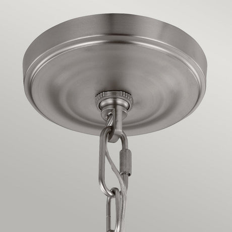 The Vintner 3 Light Chandelier in Satin Nickel is elegantly supported by a brushed metal ceiling canopy with an attached chain. It features opal etched glass shades and a satin nickel finish, ensuring a secure connection against the smooth, light gray background.