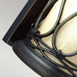 Close-up of the Wellfleet 1 Light Outdoor Wall Lantern in aged bronze, showcasing a wrought iron frame with intricate patterns over a frosted glass shade, seamlessly blending into a contemporary design. Ideal for use as bathroom lighting, this lantern is mounted on a flat wall panel.