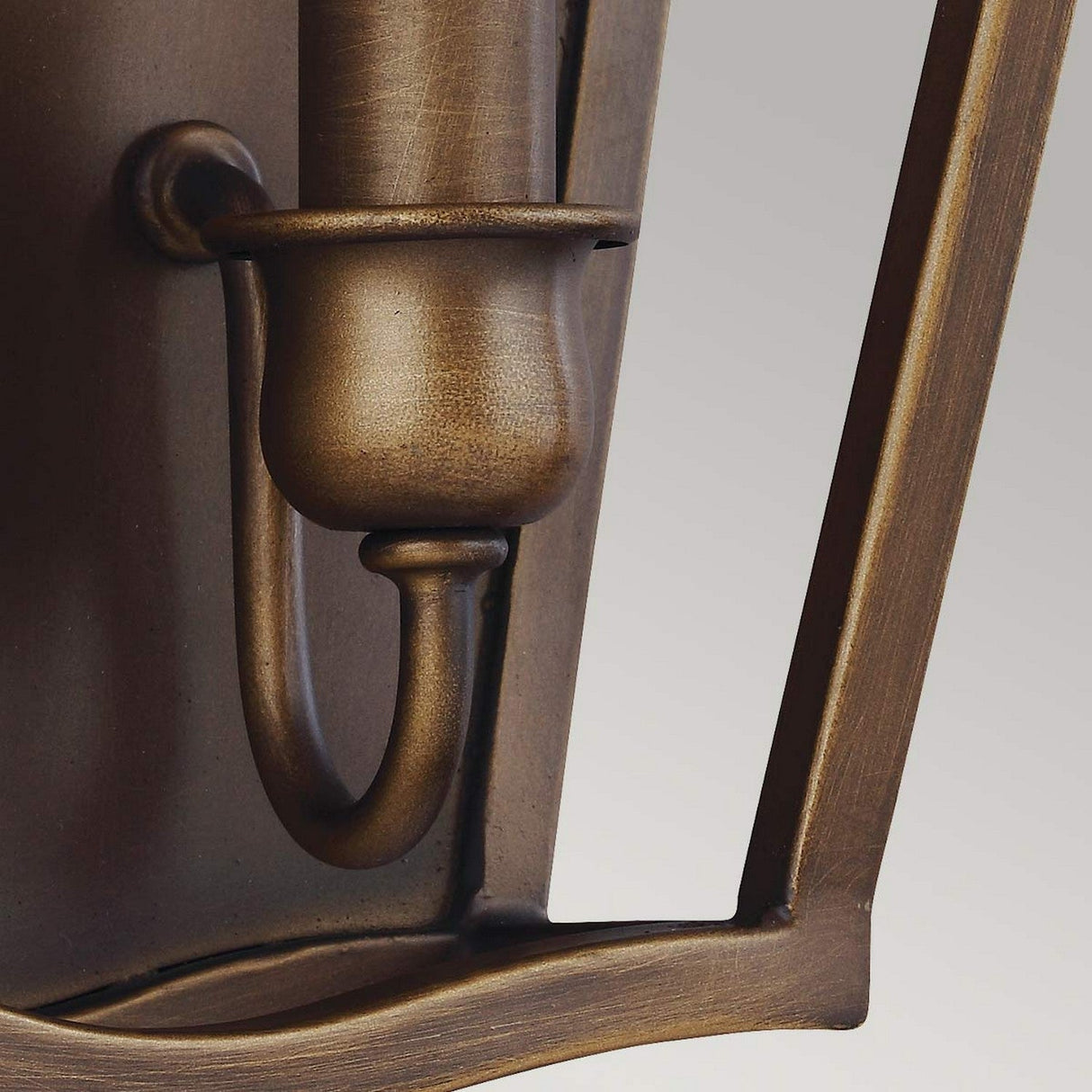 Close-up of the Yarmouth 2 Light Wall Light in Painted Aged Brass, featuring a candle-like holder and an arched design. The metal boasts a smooth finish against a soft gray background.