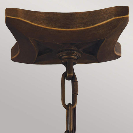 A close-up of the Painted Aged Brass ceiling mount, adorned with a decorative chain, is set against a plain background. This design showcases curved edges and intricate craftsmanship akin to the elegant Yarmouth 4 Light Chandelier.