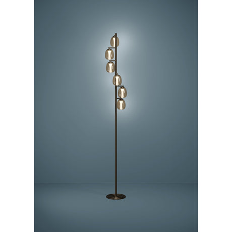Ferro LED Floor Lamp in dark bronze with six amber-tinted oval glass shades stepped along a slim stem on a round base, shown lit against a blue-grey backdrop.