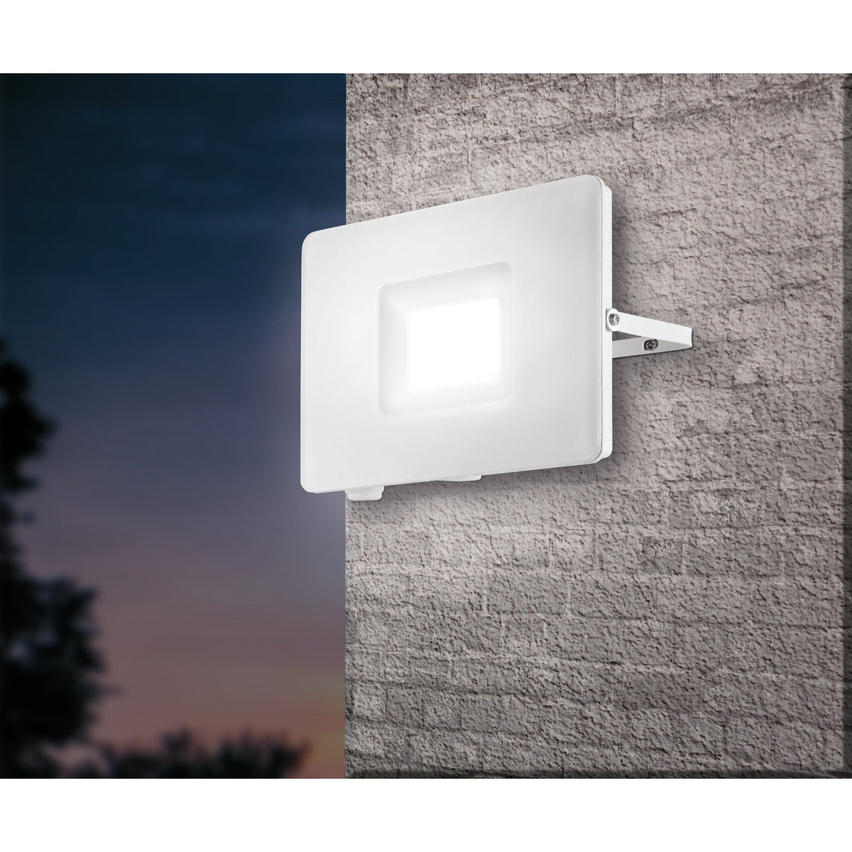 Fesvine LED Flood Light in white aluminium with recessed glass front, mounted on an exterior brick wall at dusk, illuminated with daylight white light.