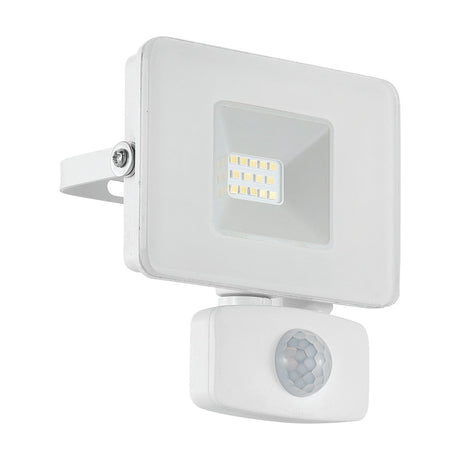 Fesvine LED flood light in white aluminium with clear glass front and integrated LED panel, mounted on a wall bracket above a round motion sensor, shown on a plain white background.