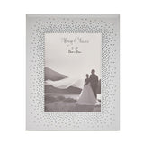 Rectangular mirrored photo frame in silver with dense starburst crystals around the opening, holding a 5x7 black and white wedding photo, shown on a white background.