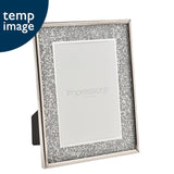 Rectangular photo frame with a broad silver glitter border and shiny silver rim, shown on an easel stand against a white background.