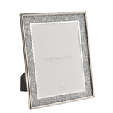 Rectangular glitter photo frame in silver with sparkling border and shiny rim, 6x8in size, shown at an angle on its easel stand against a white background.