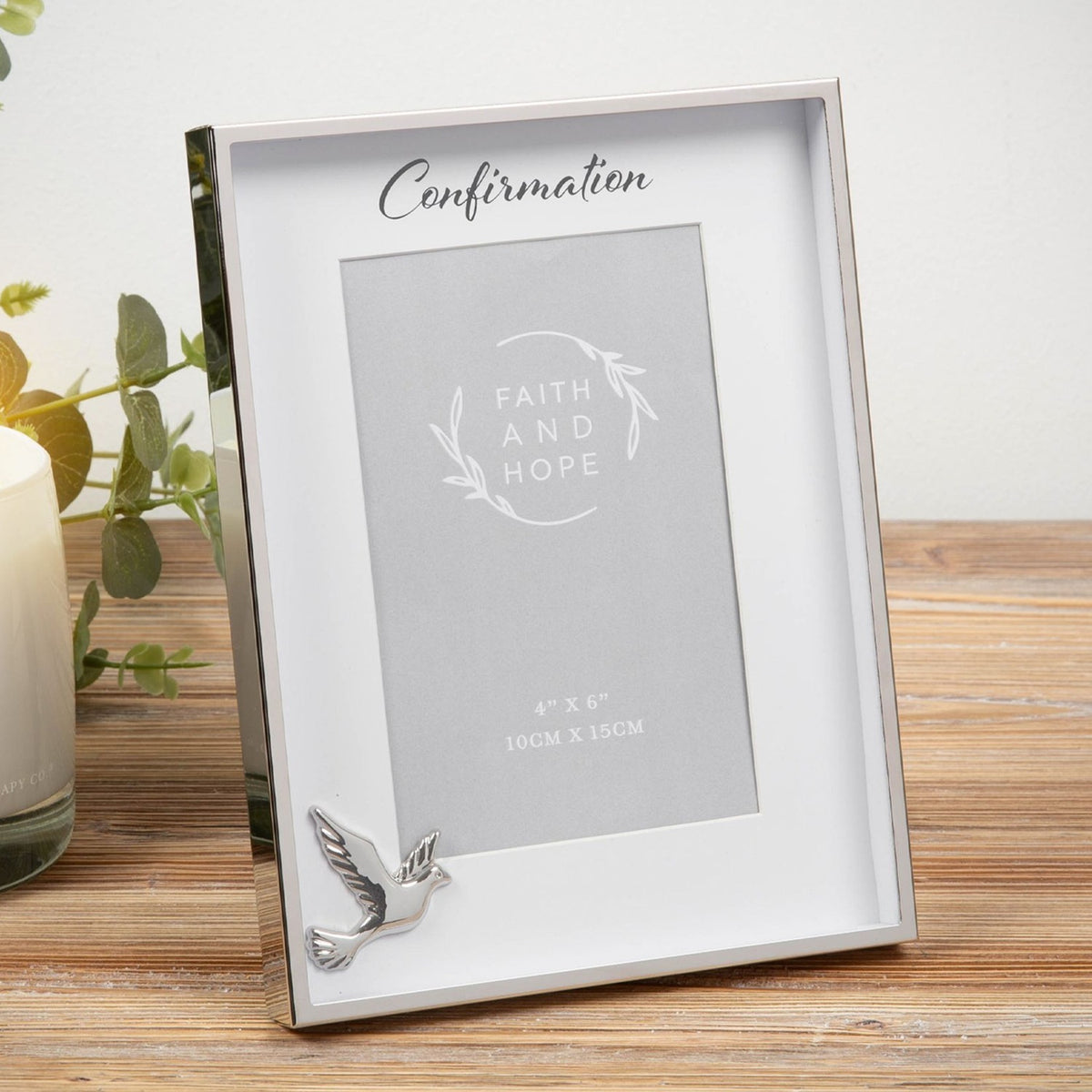 Silver metal box photo frame with "Confirmation" script text, white mount, and polished dove detail, holding a 6 x 4in photo, shown on a wooden surface.