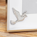 Close-up of the Confirmation Dove Metal Box Photo Frame 6 x 4in in silver, showing the polished nickel-plated dove detail on the white mount corner.