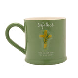 Green stoneware mug with cream interior, featuring a raised gold cross and leaf design, "Godfather" in white script, and "Thank You For Being Part Of My Story" text, on a white background.