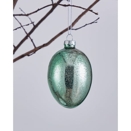 Fintry decorative glass egg in mint green with crackled, silvered antique finish and silver wire loop cap, hanging from a branch against a plain light background.